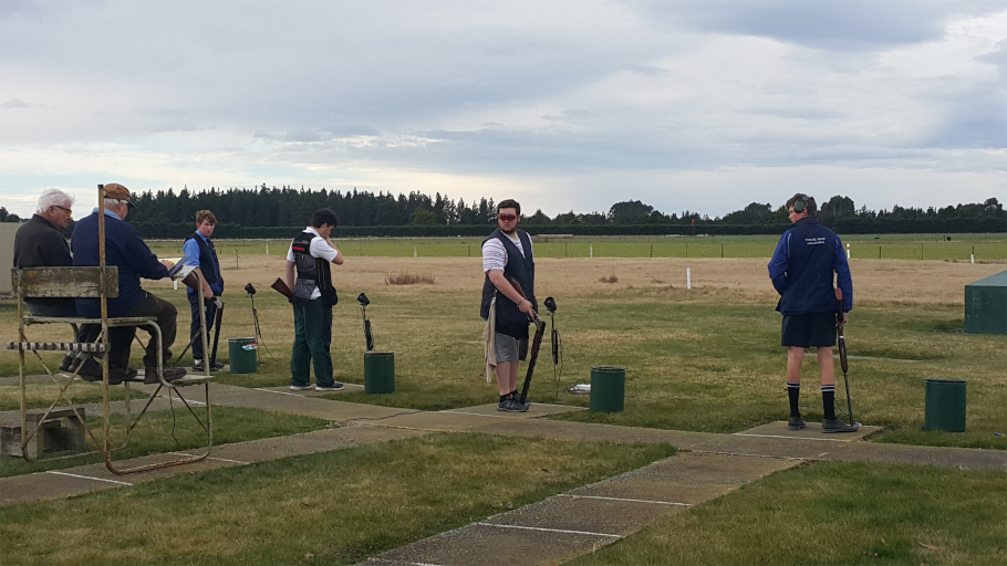 Four students shooting clay birds with two supervisors